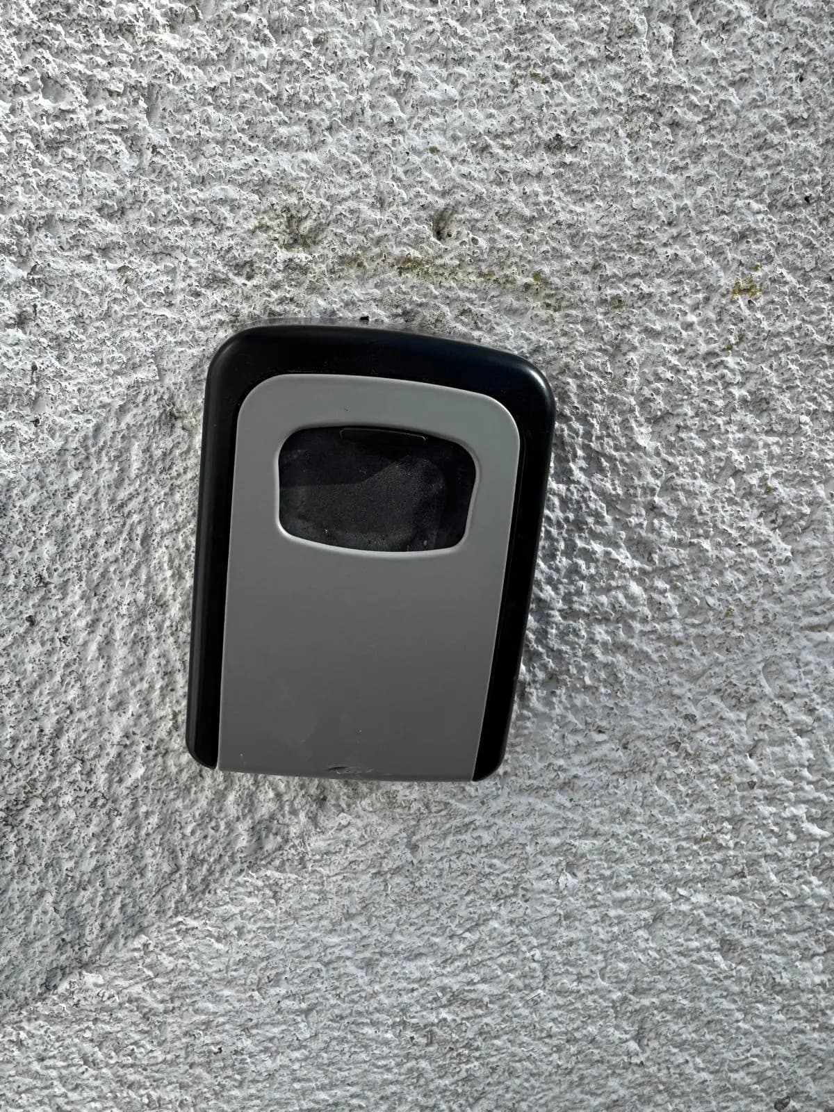 Locksmith installing a key safe at a residential property