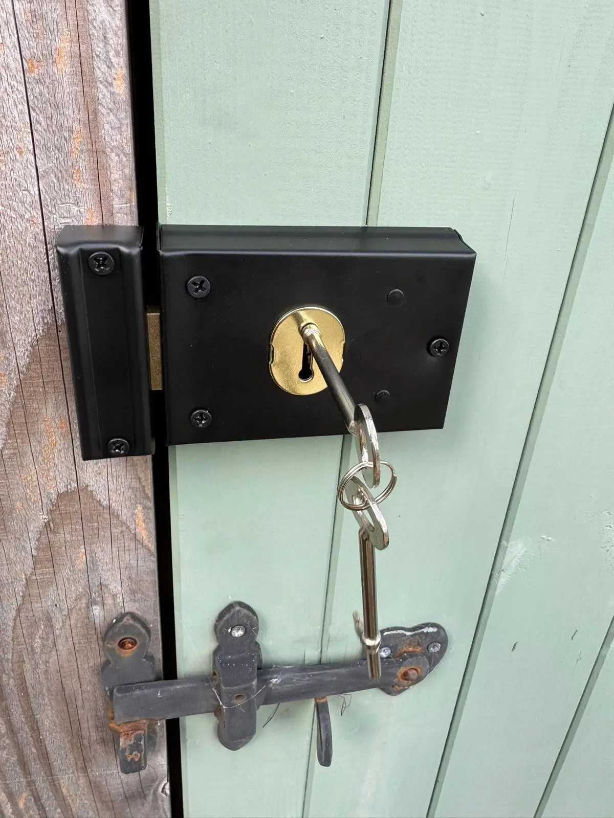Locksmith fitting a deadlock to a shed door
