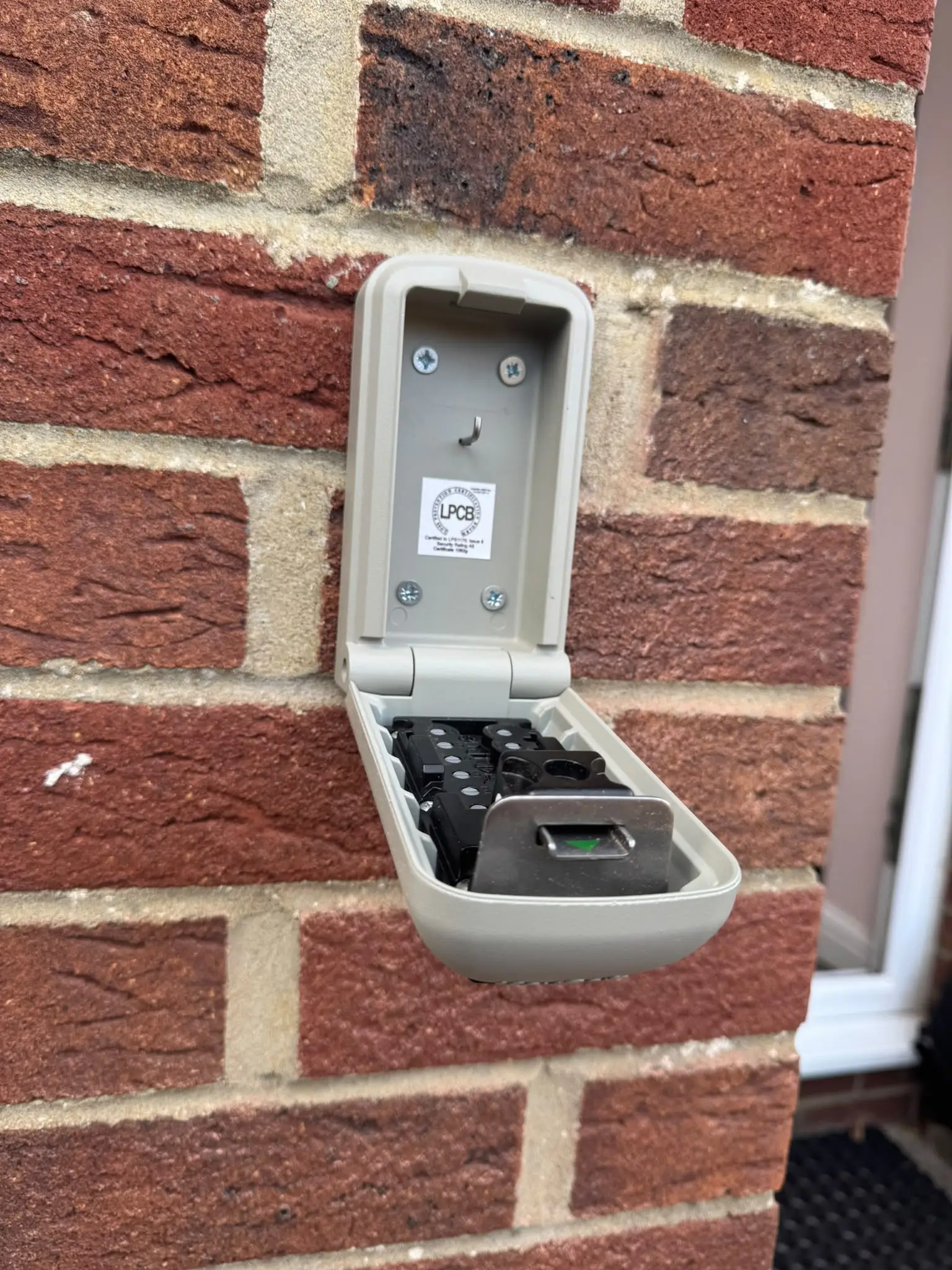 Locksmith installing a key safe at a residential property